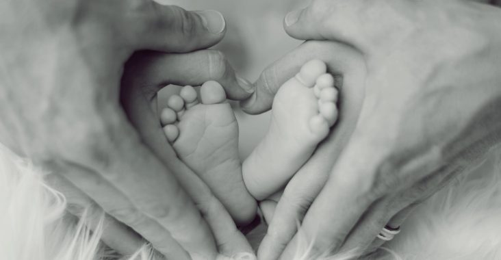 Far, mor og barn danner hjerte med hænder og fødder